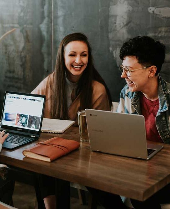 talking-happy-meeting happy colleagues have a meeting around a table with a laptop each
